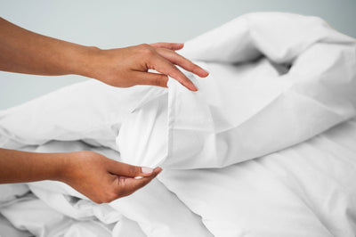 White organic cotton duvet cover with women's hand showing duvet insert.