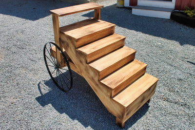 This exquisite piece used for a rustic display is constructed of solid wood with 24" metal or wooden wheels. 