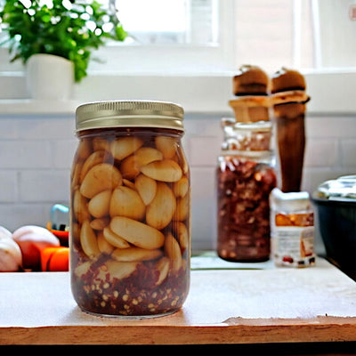 The back of a jar of Dutch Kettle Hot Pickled Garlic shows dozens of garlic cloves and crushed red pepper flakes. 
