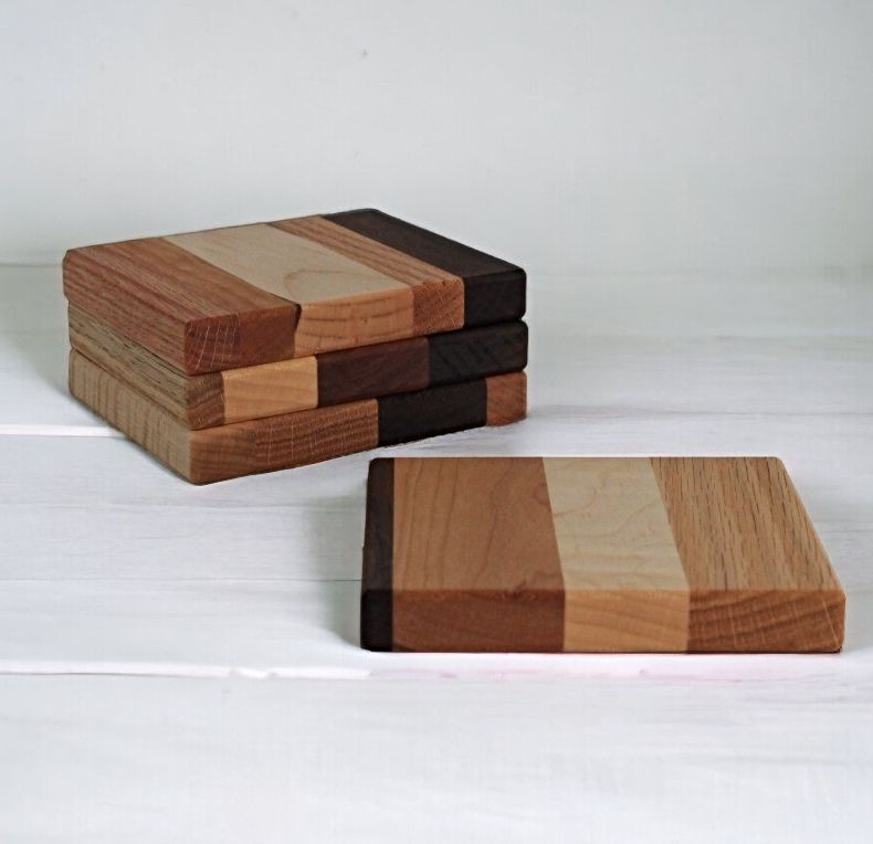 Four assorted designs od Amish Made Wooden Hot Pads. Each has 4 stripes of different color wood grains from light to dark.