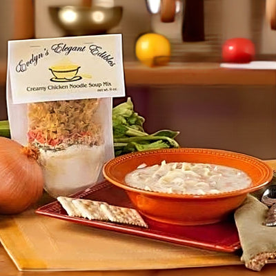 Evelyn's Elegant Edibles creamy chicken noodle soup mix with a bowl of soup on a table.