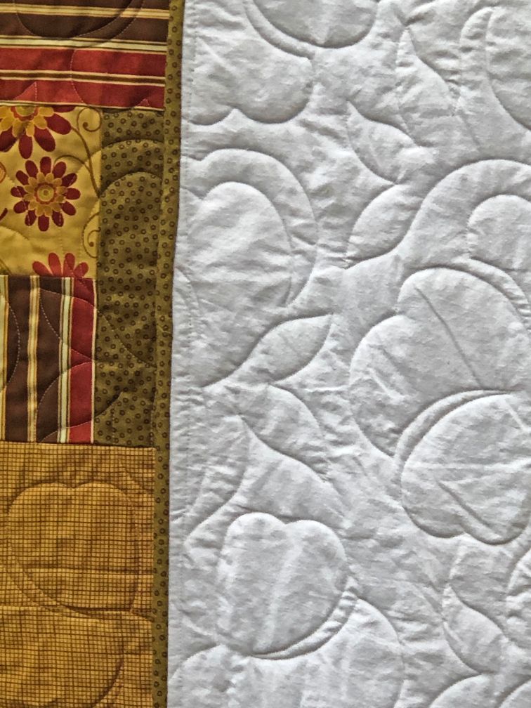 Cotton Blossom Quilting Pattern really stands out as shown on the back side of this quilt.