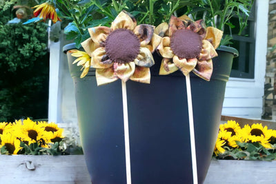 Two Handcrafted Fall Flowers on Stick Stem by a group of Sunflowers