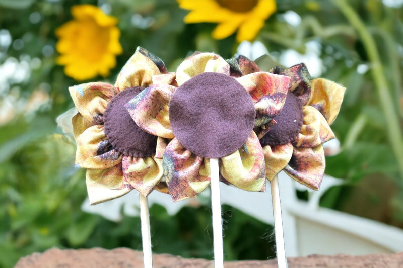 Three Handmade Fall Flowers on Sticks in the ground.