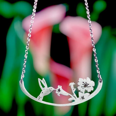 Our Hummingbird drinking sweet nectar from a flower stainless steel necklace is available in our jewelry or gifts collection at Harvest Array.