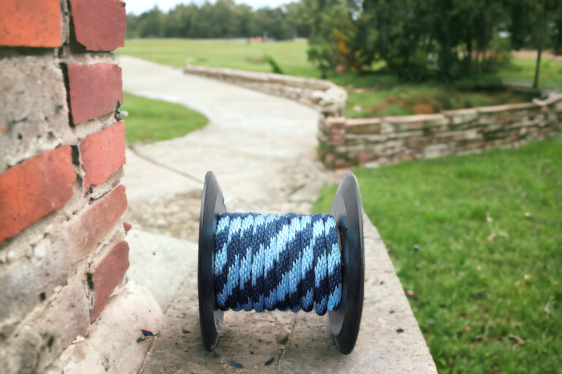 Sky Blue and Navy Solid Braided Multifilament Polypropylene Rope by a brick wall