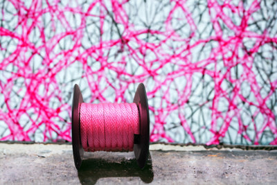 Hot Pink Solid Braided Multifilament Polypropylene Rope by a Pink Wall