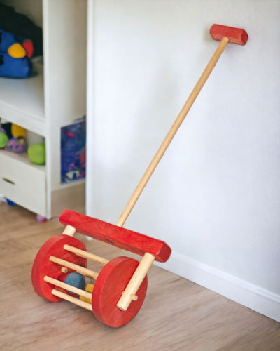 Red and Natural Colored Wooden Toy Block Roller in a playroom.