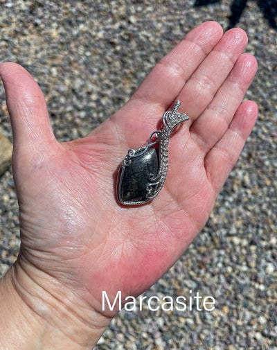 The dark green tones and golden flecks in the Nipomo Marcasite Agate show through in this photo of the pendant.