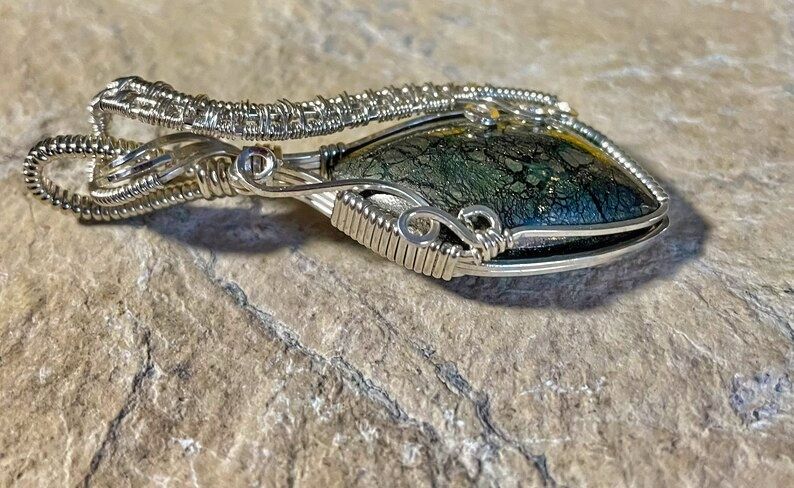 The Sterling Silver Wire is artistically wrapped but securely encases the cabochon as seen in this side view of the pendant. 
