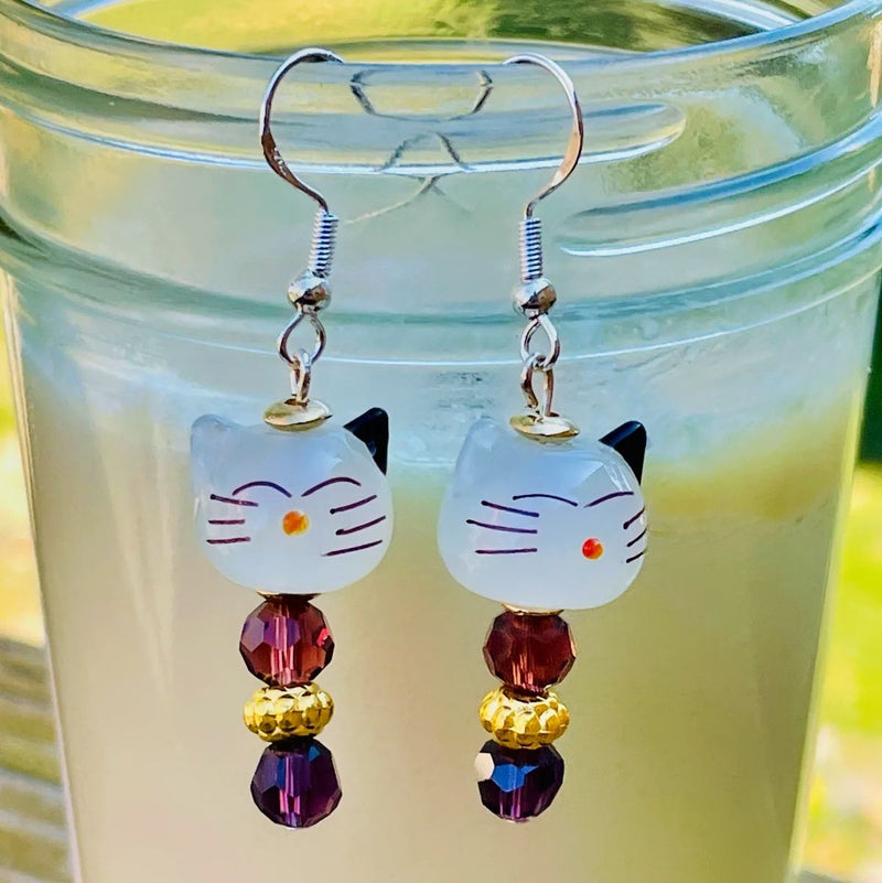 Cat Face Lamp Work Glass Bead Earrings with purple accent beads.