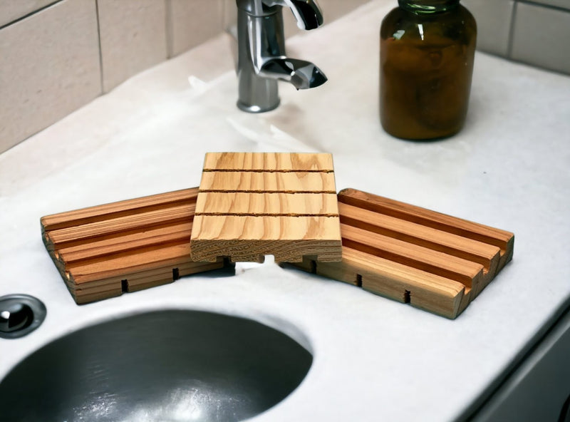 A set of three cedar soap dishes on the sink