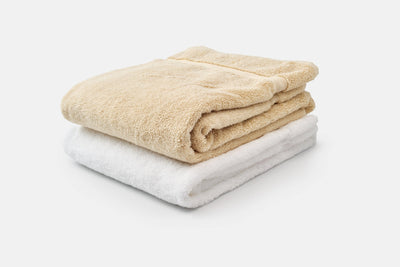American Blossom Linens organic white and natural towels folded and stacked.