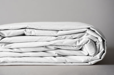 White organic cotton duvet cover folded for storage.