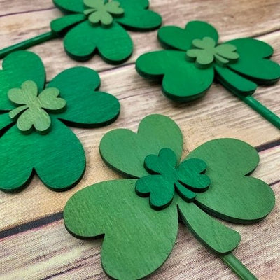 A close up of Harvest Array's Shamrock Duo Wooden Garden Stakes with Shimmer Accent