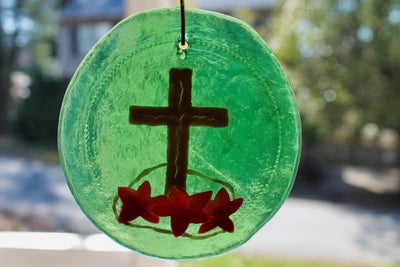 Gold cross on green glass suncatcher