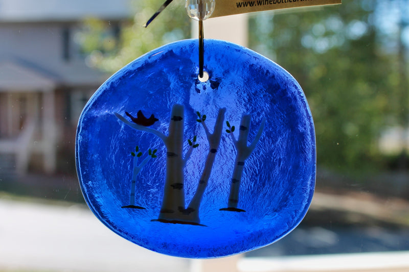 Birds in birch trees on blue glass