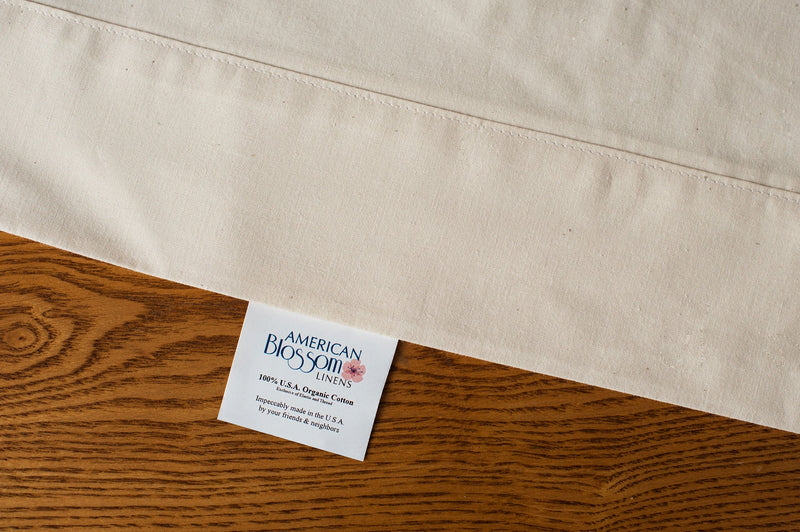 Organic cotton pillowcases in natural color showing pillowcase label.