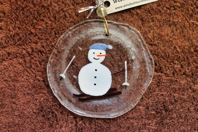 The snowman is hitting on slopes on this glass ornament and suncatcher