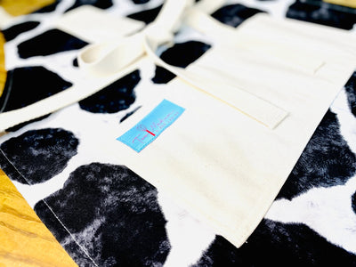 Close up view of the Susanna Cow Print Apron
